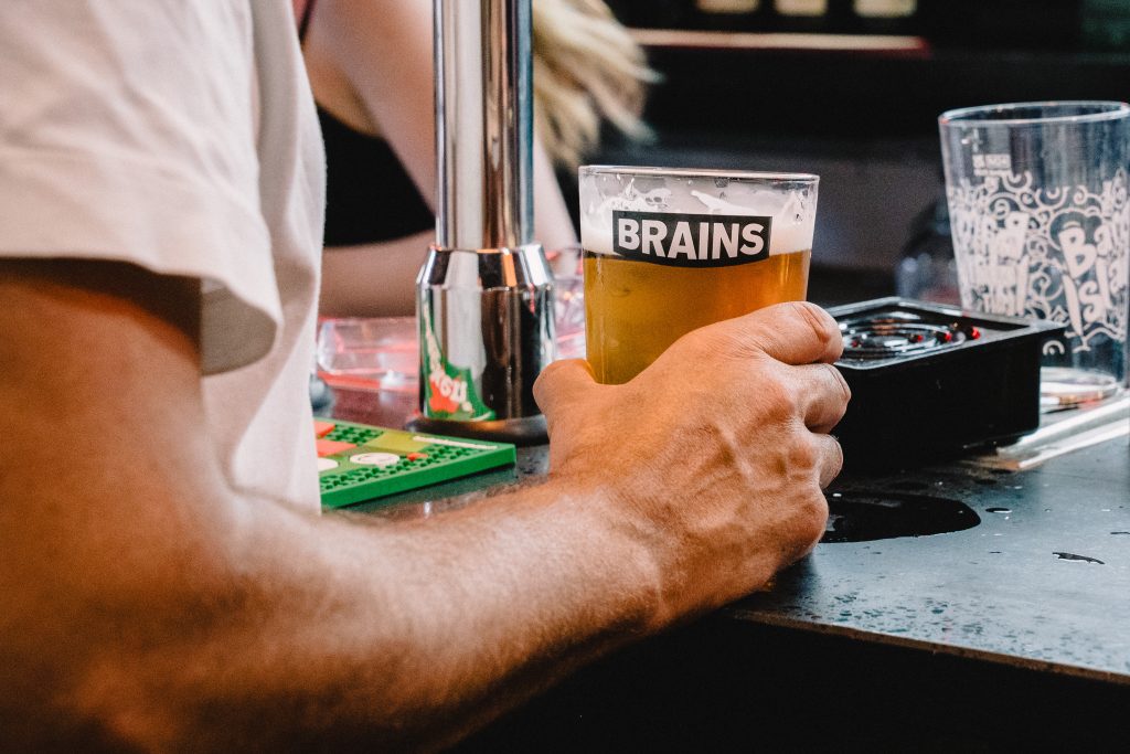Customer holding a pint of Brains