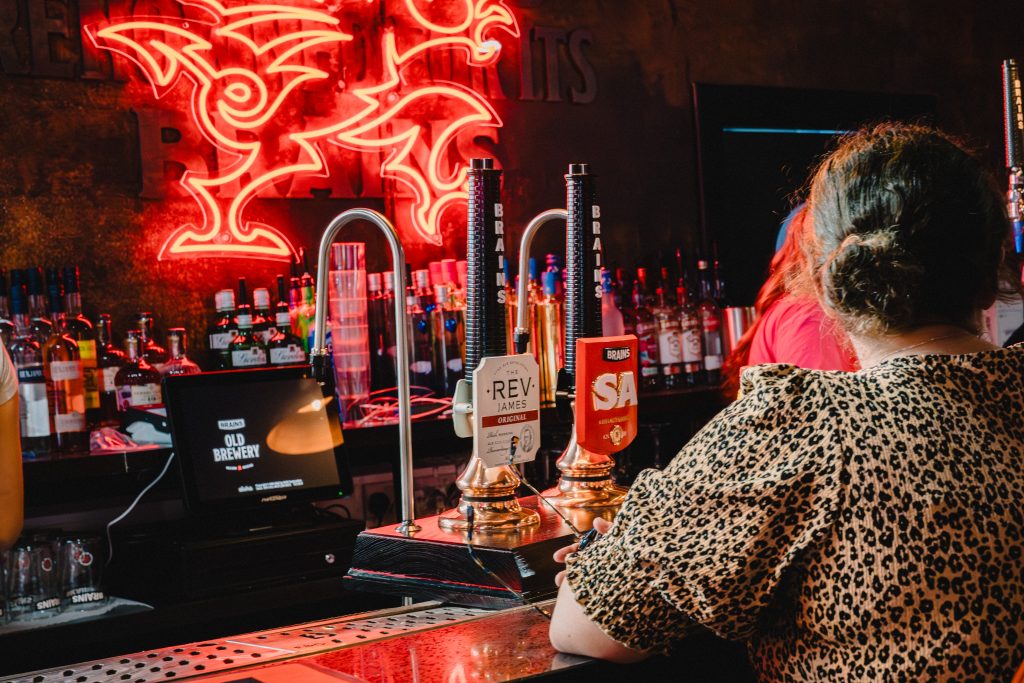 customer at bar by brains beer pumps